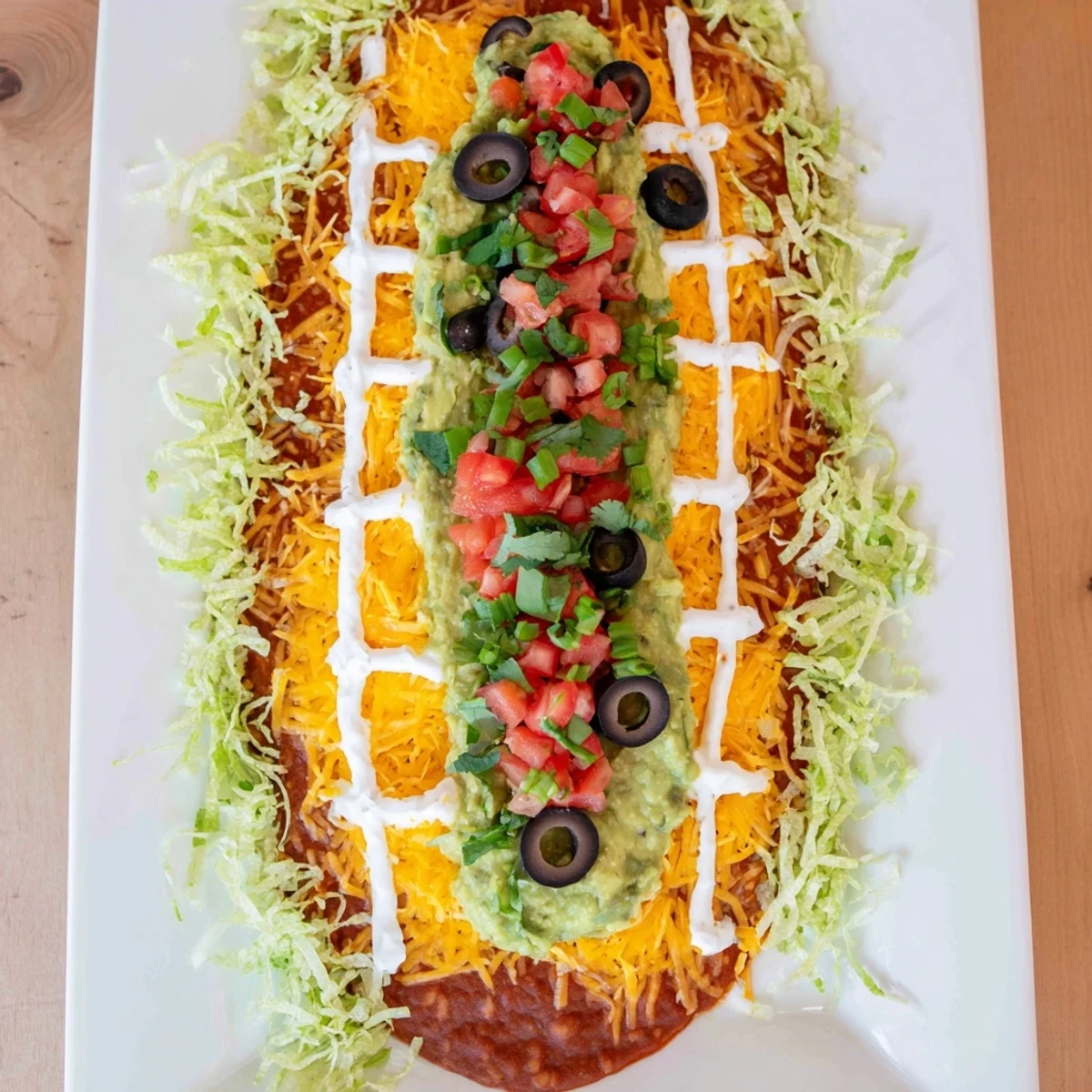 Enjoy the delicious Football Field Dip with chips, featuring creamy layers and fresh cilantro garnish.