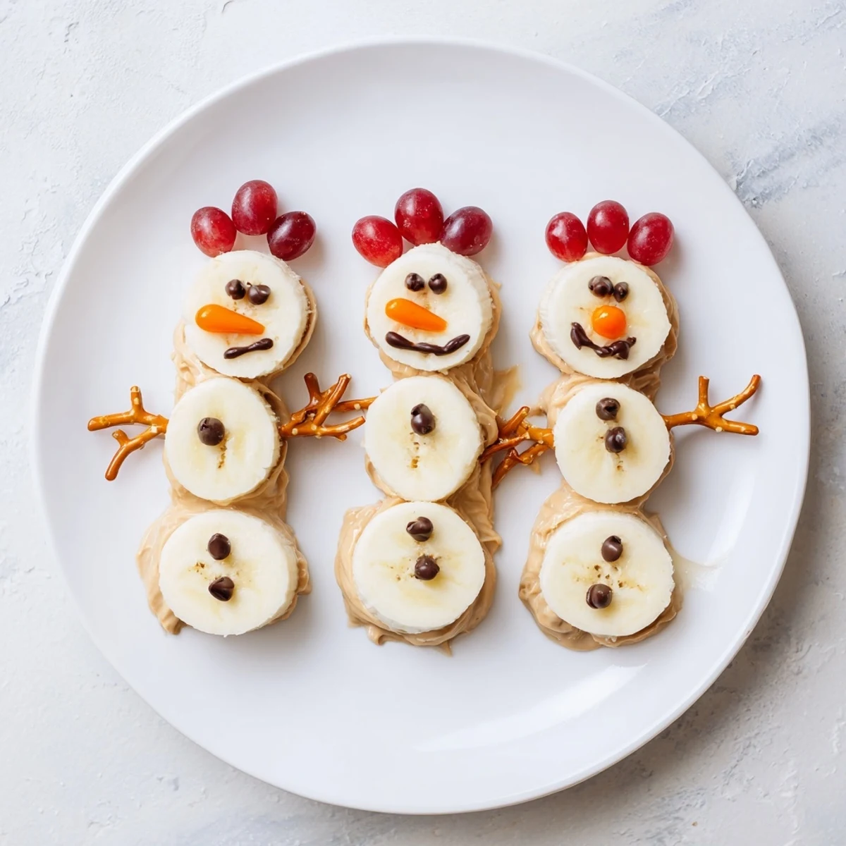 Adorable Banana Peanut Butter Snowmen are pictured, crafted with peanut butter and festive decorations for kids.