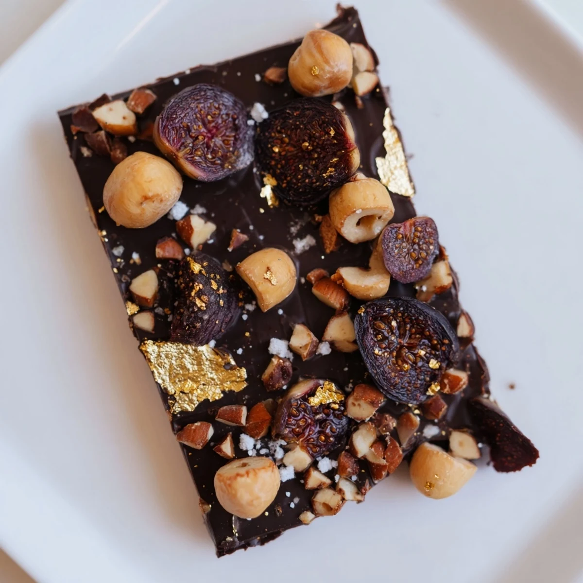 A square of The Midnight Mosaic shows a dark chocolate base topped with vibrant figs and olives.