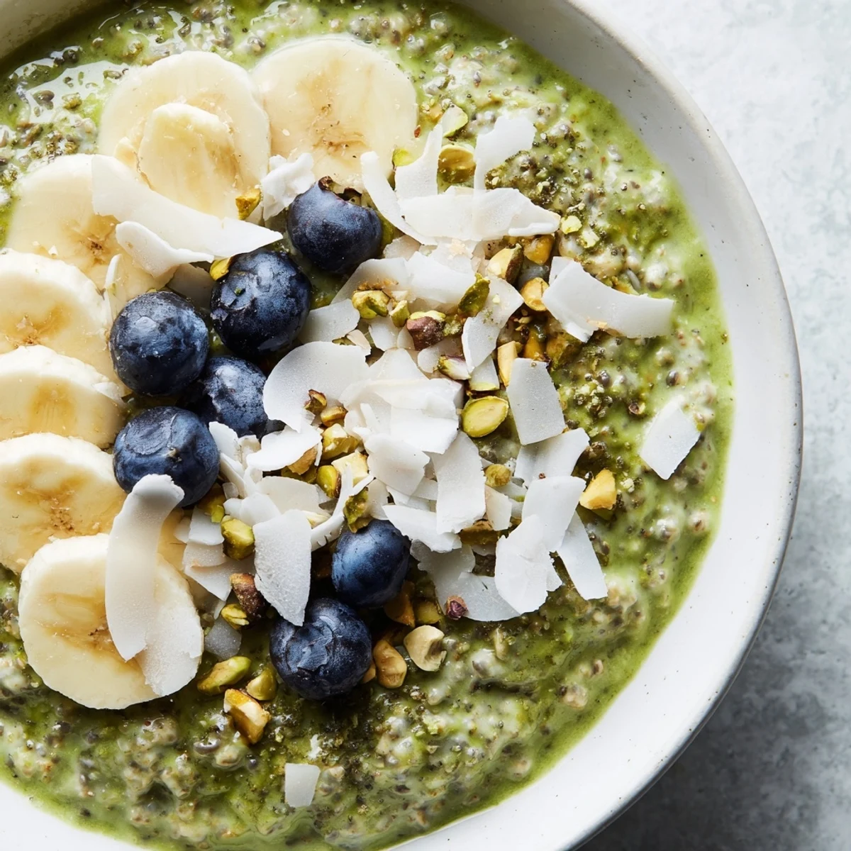 Vibrant green Matcha Overnight Oats topped with fresh berries, ready for a delicious breakfast.