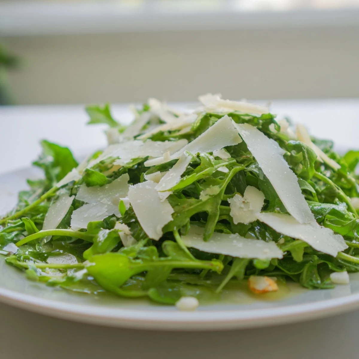Fresh arugula salad with a bright lemon dressing, Parmesan shavings, ready to serve at once.