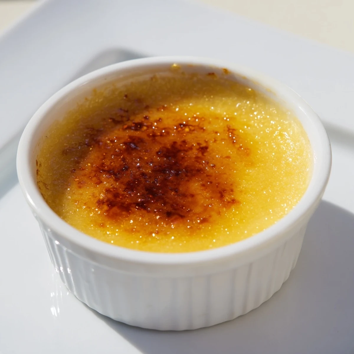 Rich, decadent 3-Ingredient Crème Brûlée, showing the silky custard under a caramelized sugar layer.