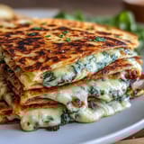 Vibrant green spinach and melted cheddar fill festive shamrock quesadillas, ideal for family-friendly holiday meals.