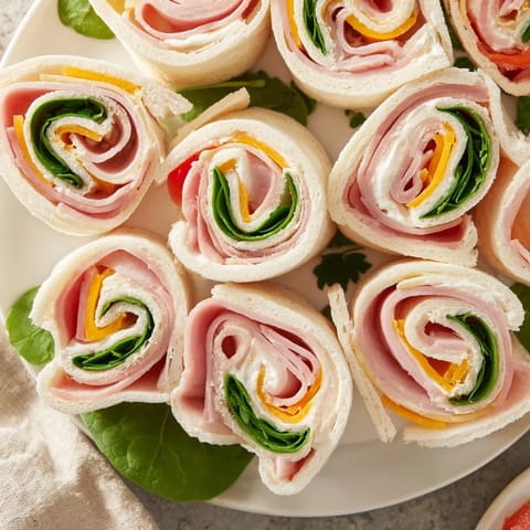 Beautiful star-shaped Party Sandwiches, featuring layers of deli meat, cheese, and vegetables.