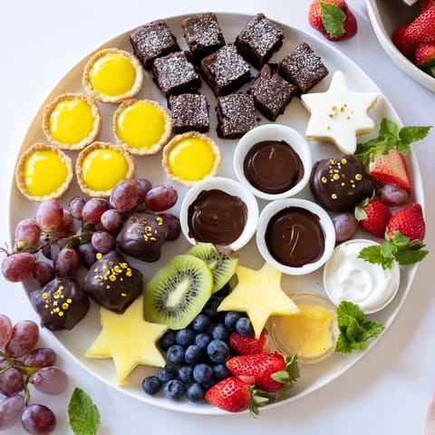A glorious Star-Studded Dessert Board overflowing with chocolate, fruit, and sweet dips for a party.