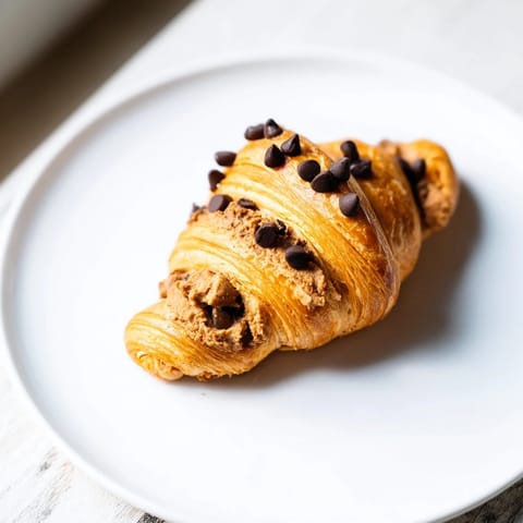 Warm, gooey Chocolate Cookie Croissants, with a chocolate chip cookie center, looking irresistibly delicious.