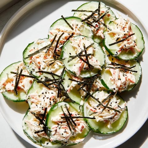 California Roll Cucumber Salad served in a chilled bowl, garnished with tender imitation crab and vibrant pickled ginger slices.  