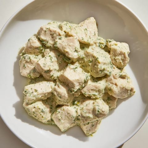 An overhead shot of protein-packed Green Goddess Chicken Salad featuring sliced avocado, cucumber, and juicy tomatoes on a bed of fresh greens.  