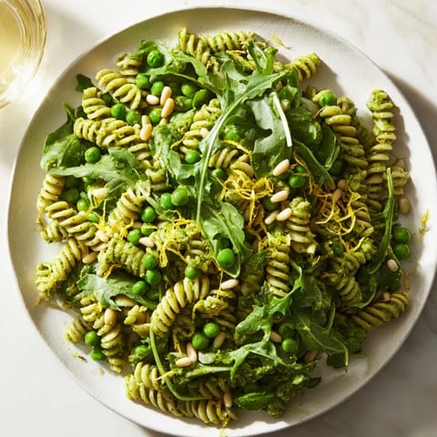 Freshly tossed Spring Green Pesto Pasta Salad featuring creamy homemade pesto and bright lemon zest.