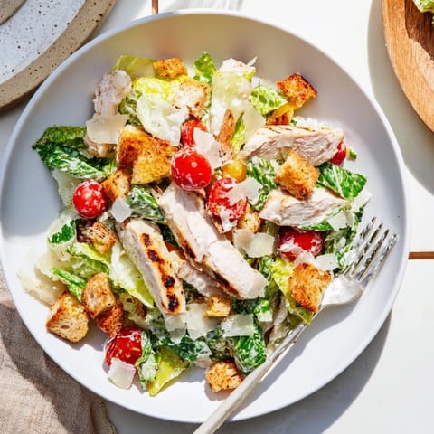 Tender grilled chicken strips rest atop crisp romaine in this vibrant Yogurt Caesar Grilled Chicken Salad.