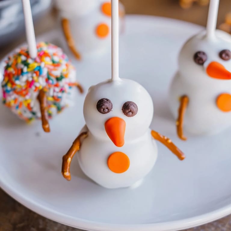 Homemade Oreo Snowman Cake Pops, decorated with mini chocolate chips, look festive and delicious.