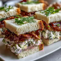 Elegant Kentucky Derby tea sandwich trio with cucumber, egg salad, and ham on assorted breads, perfect for Derby parties.